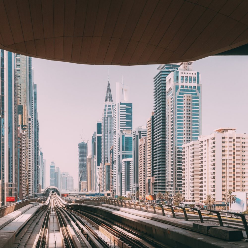 Modern Dubai Metro. Metro railway among glass skyscrapers in Dubai. Traffic on street in Dubai